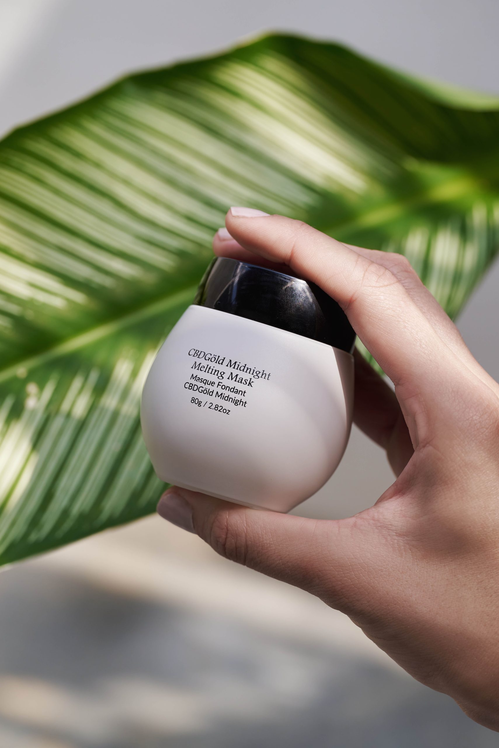 Hand holding CbGardn leave-on mask with peptides