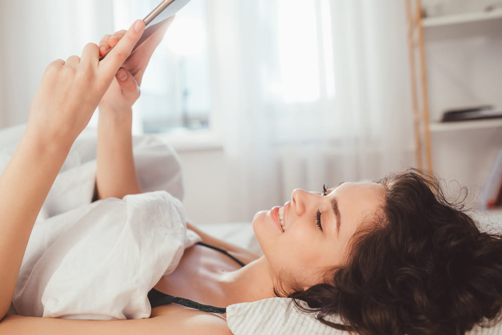 Woman in bed looking at phone